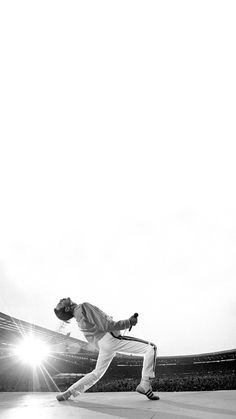 a man swinging a tennis racquet on top of a tennis court with the sun behind him