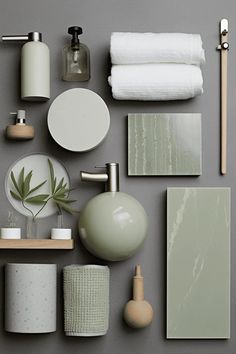 various bathroom accessories arranged on a gray surface with white and green accents, such as soap dispensers, toothbrushes, toilet paper towels and other items