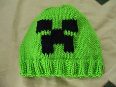 a green knitted hat with black letters on it