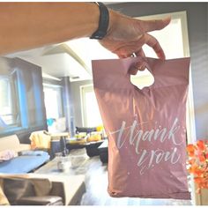 a person holding a pink bag that says thank you