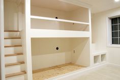 an empty room with some shelves and stairs