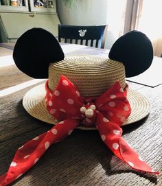 a minnie mouse hat with a red polka dot bow around it on top of a table