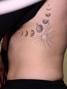 a woman's stomach with phases of the moon and sun on it