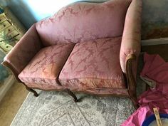 a pink couch sitting on top of a rug