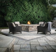 an outdoor fire pit with chairs around it