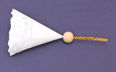 a small white paper cone with a yellow bead on the end and a gold tip