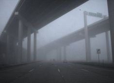 an overpass with cars driving on it in the fog