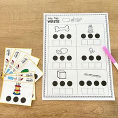 a wooden table topped with lots of paper cut out to spell the word write and color