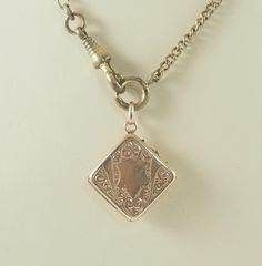 A charming antique Victorian lozenge shaped locket or watch chain fob in gold filled, rolled gold, in a rose gold tone.  The  locket is set to one side with a mother of pearl panel. To the other side is gold filled with a shield shaped cartouche for initials with a scroll surround. Opening to reveal space for one square photographs, no frame or glass covering. With an oval bail. The chain is for display only. Germany, 1890-900. 4.9g The mother of pearl panel 1.7cm square when measured as a lozen Pearl Locket, Victorian Gold, First Photograph, Watch Chain, Locket Necklace, Antique Victorian, Locket, Or Rose, Mother Of Pearl