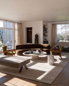 a living room filled with furniture and large windows