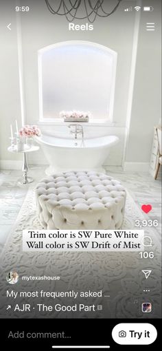 a white bath tub sitting next to a window in a bathroom on top of a rug