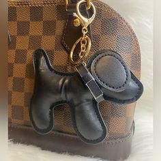 a brown and black purse with a dog keychain on it's side