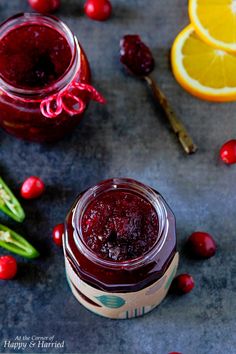 cranberry sauce in a glass jar next to sliced oranges and cucumbers