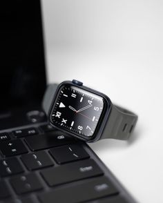 an apple watch sitting on top of a laptop computer next to it's keyboard