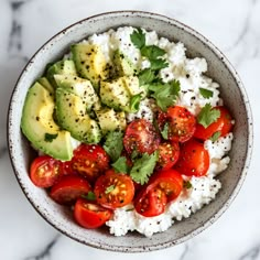 a bowl filled with rice, tomatoes and avocado