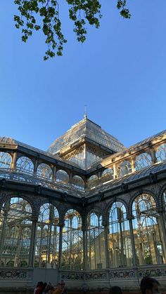 the inside of a building with many glass walls and windows on each side, looking up into the sky