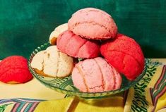 a glass bowl filled with pink and white cookies