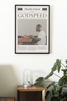 a magazine cover with a man sitting at a table in front of a potted plant