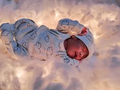 a baby is laying in the snow with its head turned to look like it's sleeping