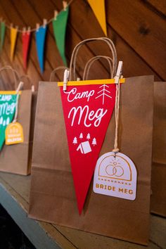 some brown paper bags are hanging on the wall and there is a sign that says camp mey