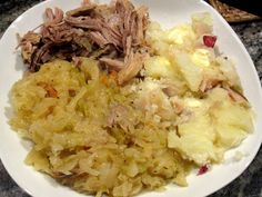 a white plate topped with meat and potatoes