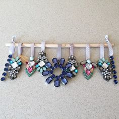 five different colored necklaces are hanging on a clothes rack with polka dots and bows