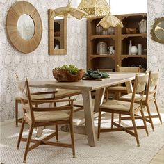 a dining room table with chairs and a bowl of vegetables on top of the table