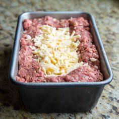 a metal pan filled with meat and cheese