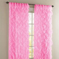 pink ruffled curtains hanging in front of a window