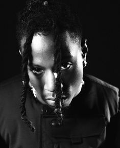 a woman with dreadlocks looking at her cell phone in black and white photo