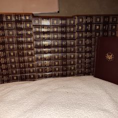 there is a bed with many books stacked on top of it and a passport in the corner