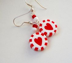 two red and white earrings with hearts on them