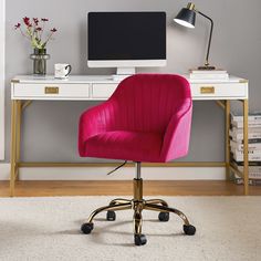 a pink chair sits in front of a desk with a computer monitor and flowers on it