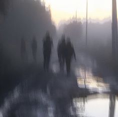 several people walking down a street in the fog