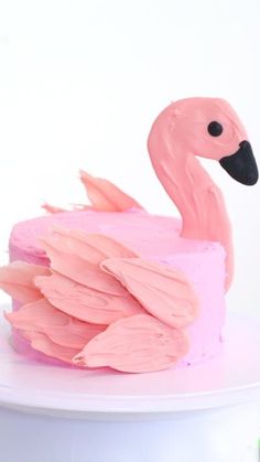 a cake decorated with pink frosting and a flamingo figure on top of it