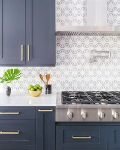 a kitchen with blue cabinets and gold trimmings on the backsplashes