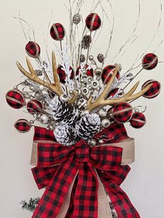 a red and black plaid bow with pineconis, silver balls and antlers