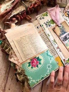 an open book sitting on top of a wooden table covered in papers and other items