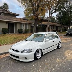 a white car parked in front of a house