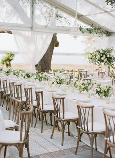 the tables are set with white linens and greenery for an outdoor wedding reception