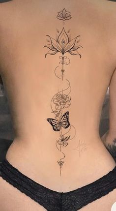 the back of a woman's body with tattoos on it