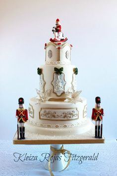 a three tiered wedding cake with nutcrackers on the top and sides