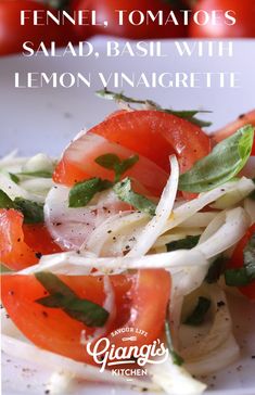 a white plate topped with sliced tomatoes and onions next to a bottle of lemon vinaigrete