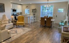 a living room filled with furniture next to a kitchen