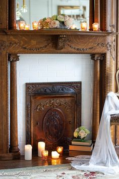 a fireplace with candles and flowers on it