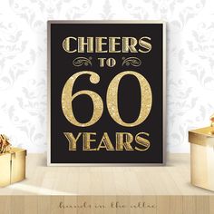 a black and white poster with the words cheers to 80 years next to some presents