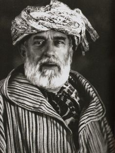 an old black and white photo of a man wearing a turban