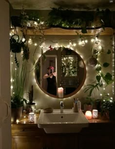 a person taking a selfie in front of a mirror with plants on the wall