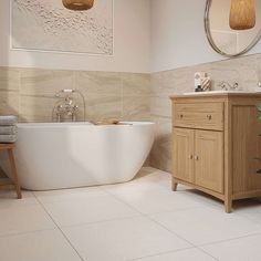 a white bath tub sitting next to a wooden cabinet in a bathroom under a round mirror