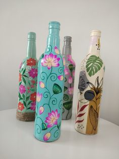 four different colored bottles with designs on them